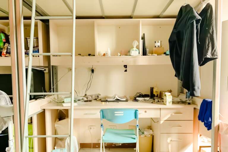 Dorm room with desk and bunk bed