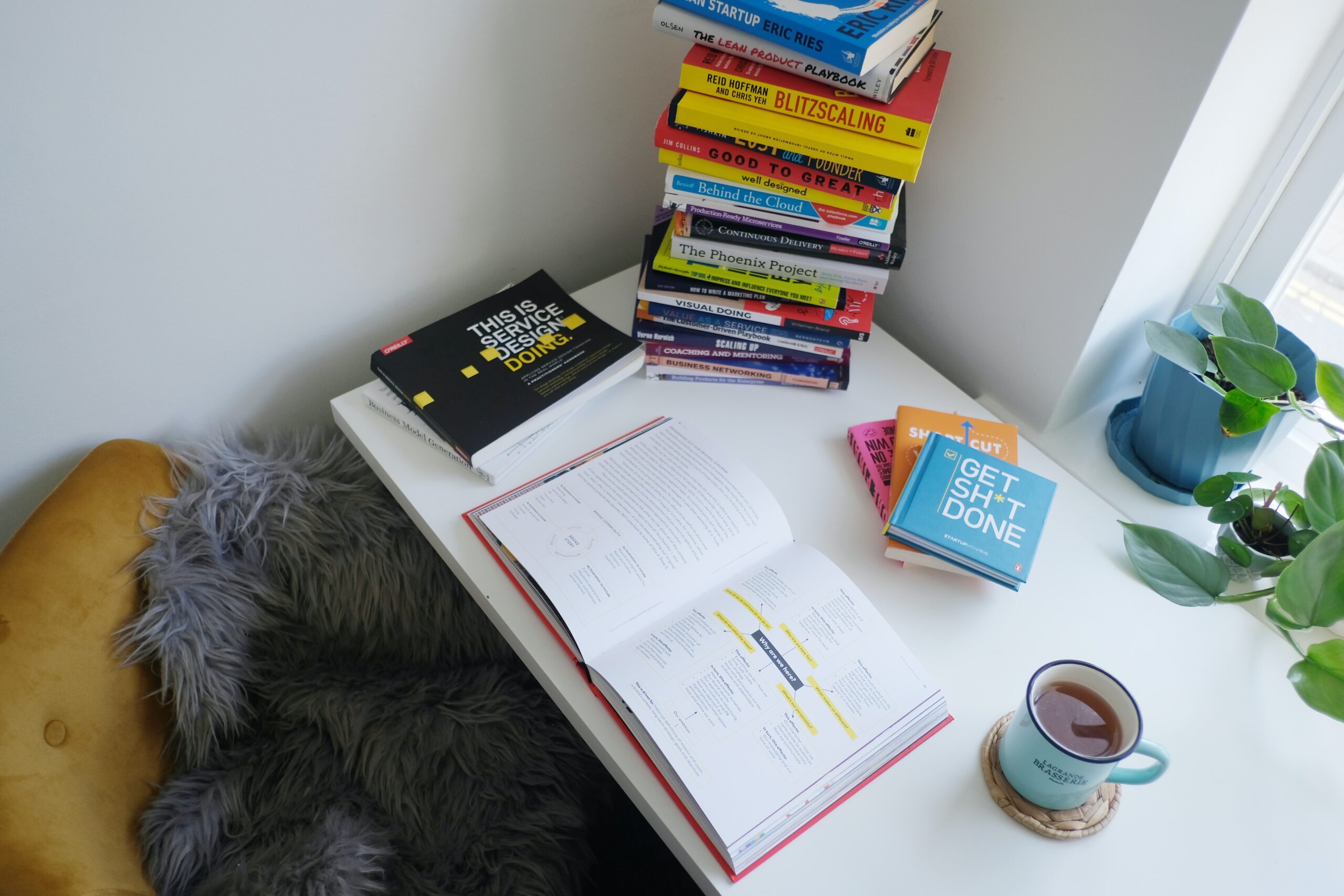 Open textbook and stack of books on a white table