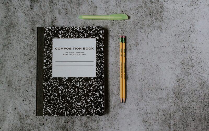 composition book, two yellow pencils, and a green highlighter