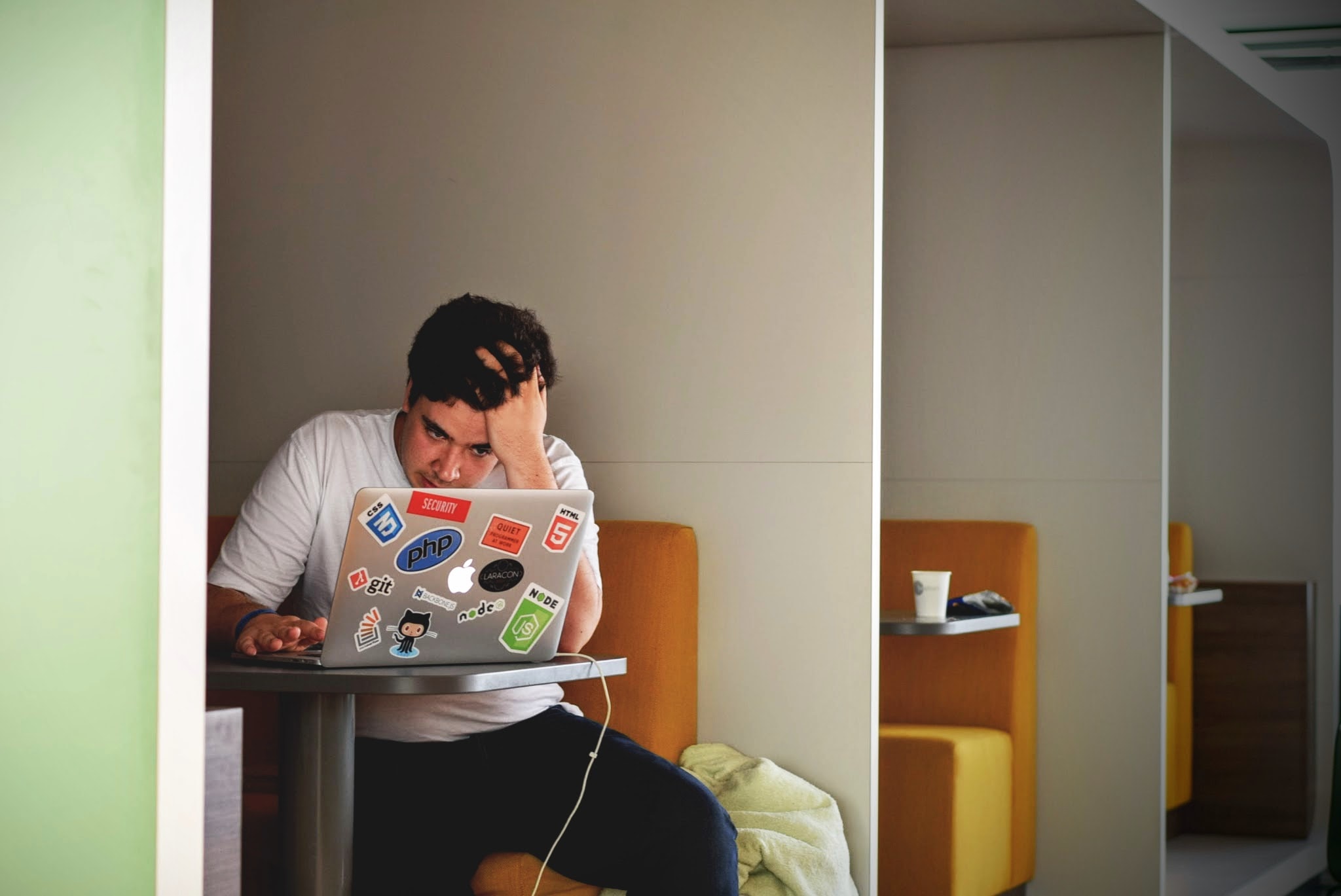 man sitting at a table using his MacBook for finals week