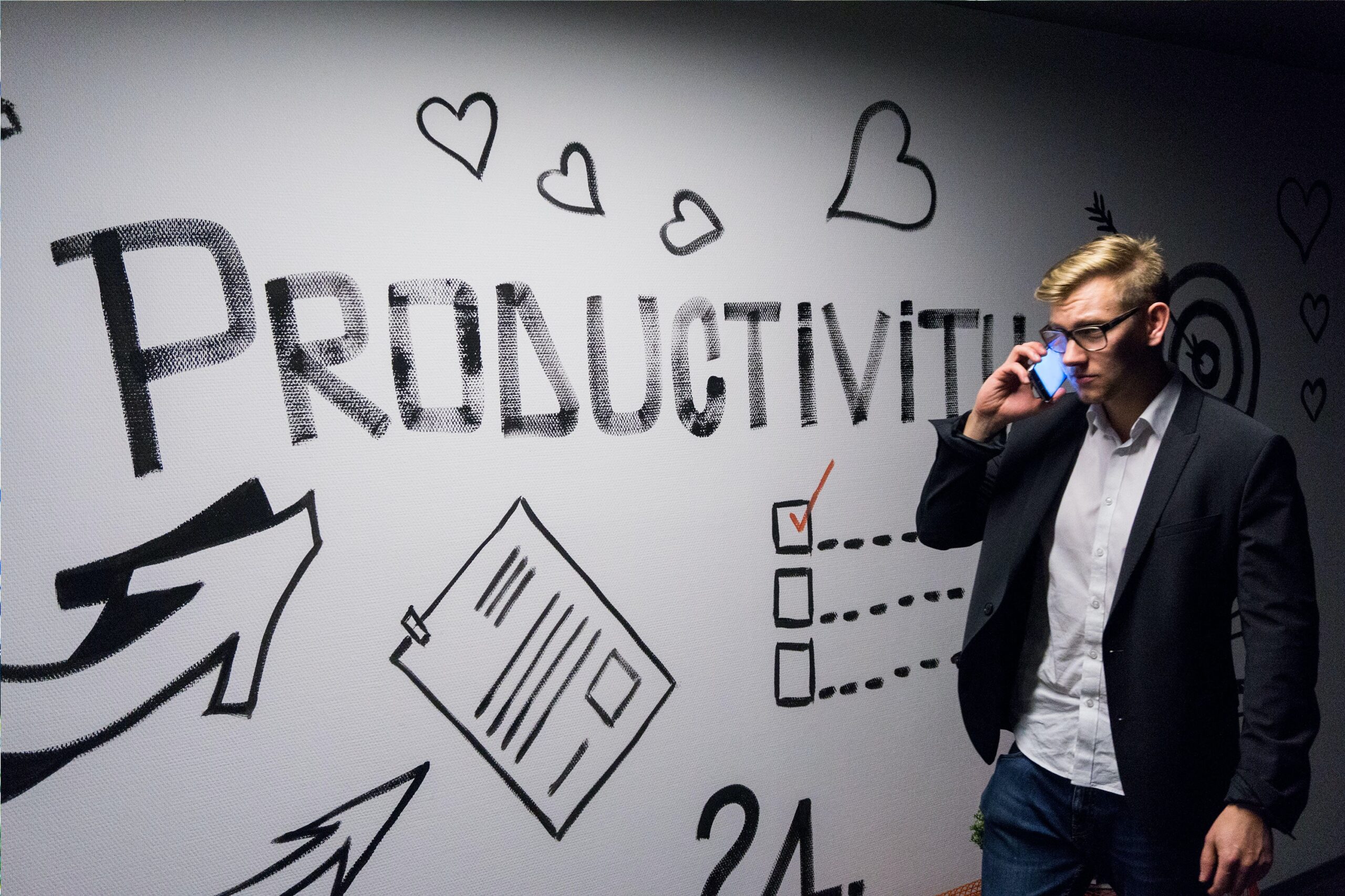 Man holding phone looking at productivity wall decor