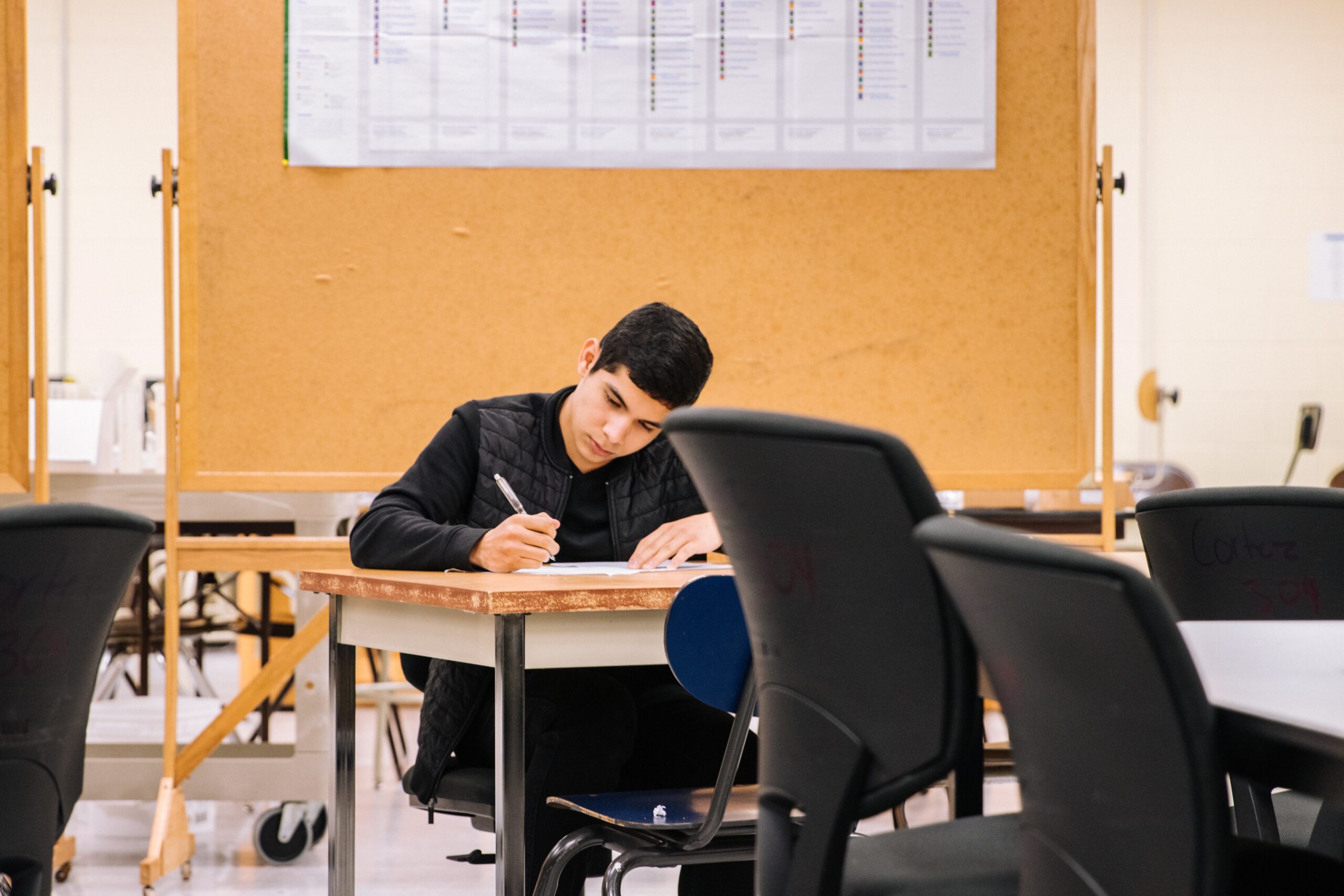Man sitting at desk and writing on a piece of paper
