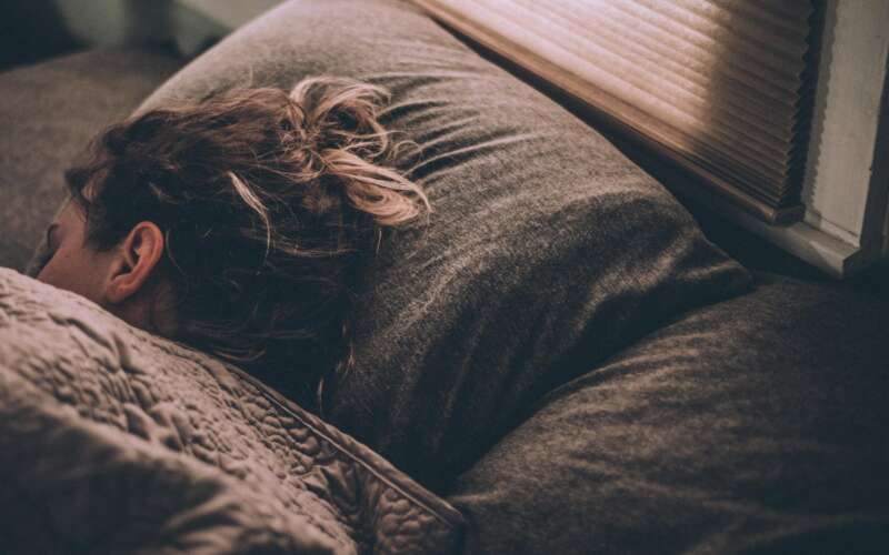 women sleeping in bed under dark gray blanket