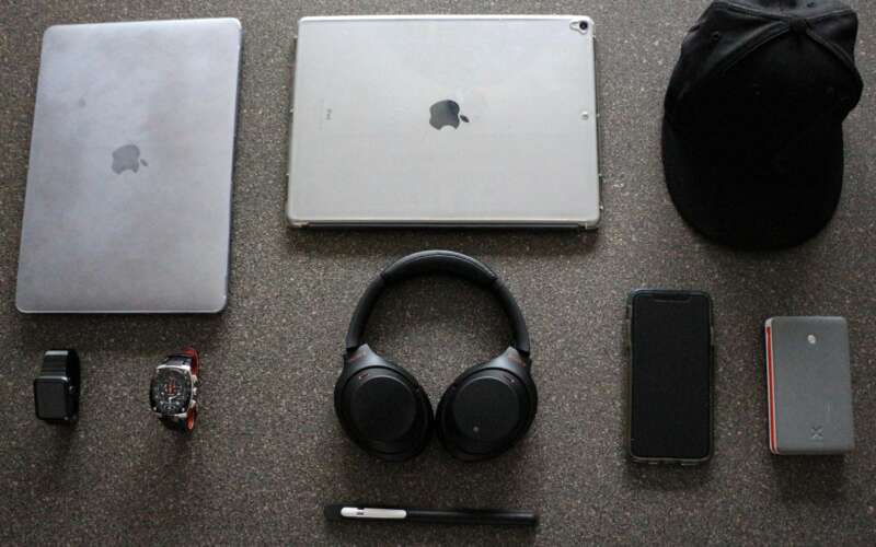 silver laptop beside silver tablet and black hat along with other edc gadgets