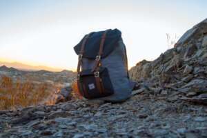 black and gray heavy duty backpack sitting on a mountain side