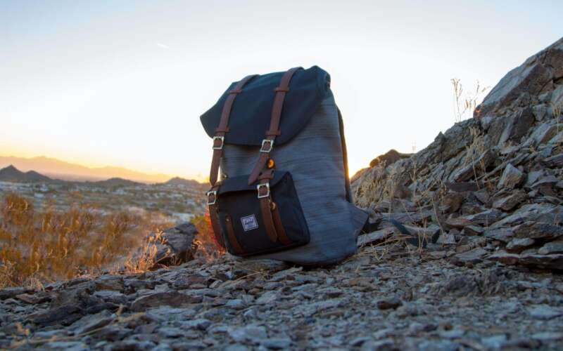 black and gray heavy duty backpack sitting on a mountain side
