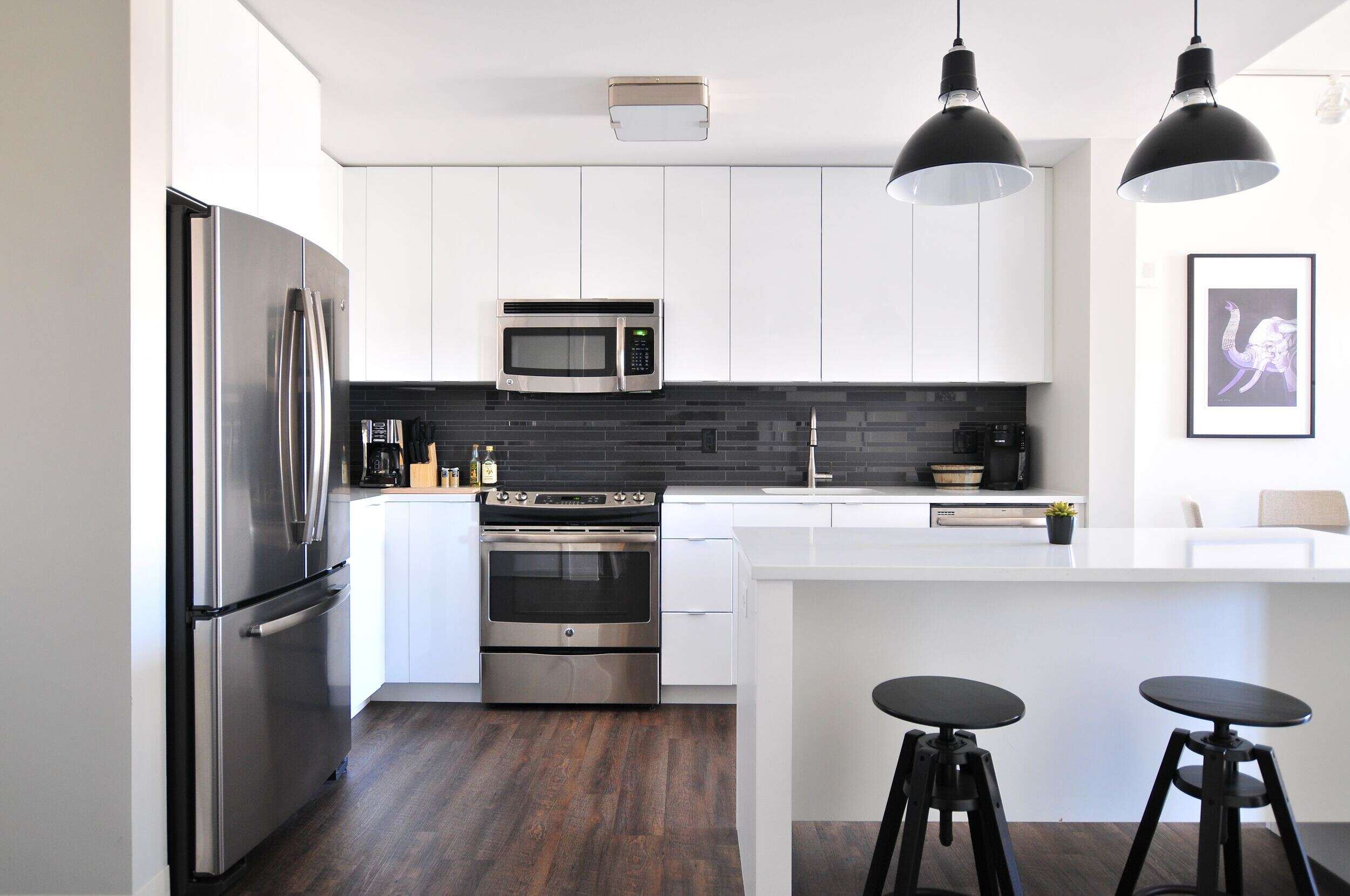 Apartment kitchen with stainless steel appliances and white countertops