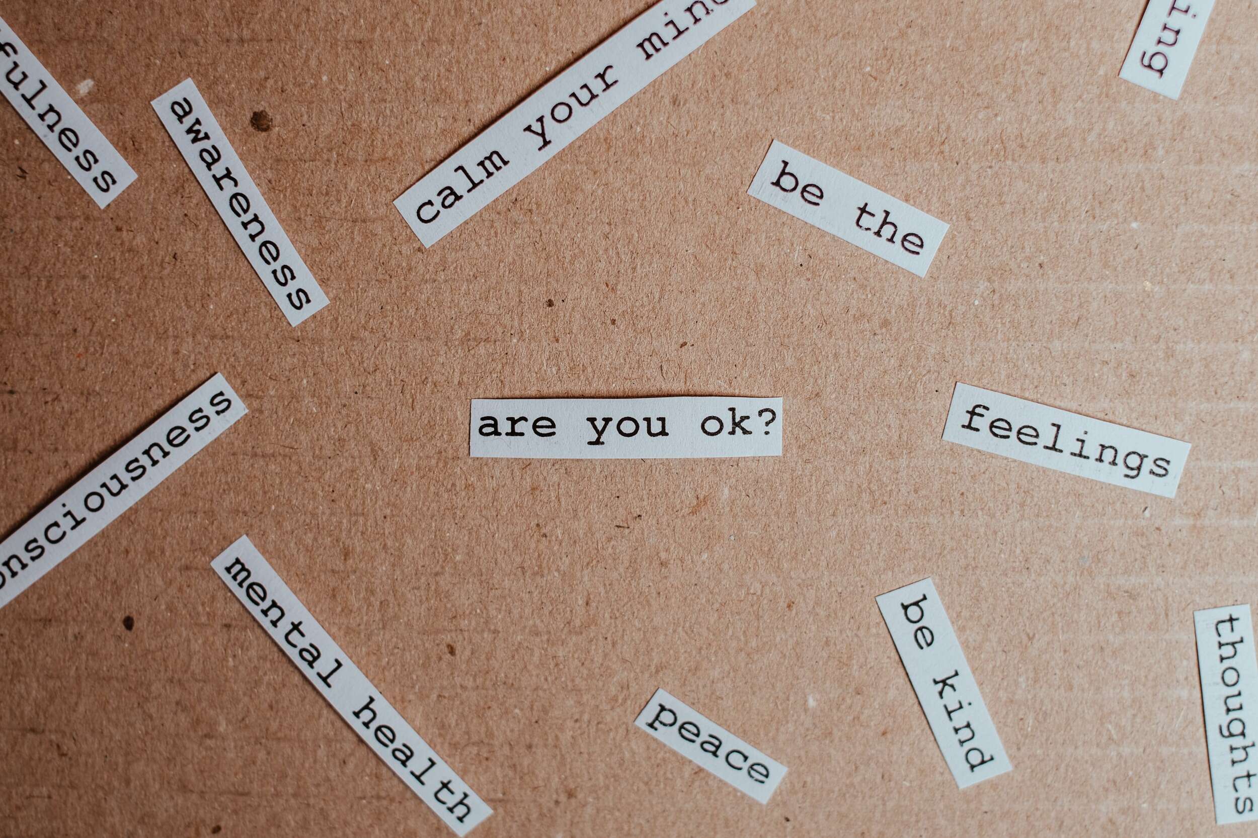 13 Easy Activities to Improve Mental Health in College Small pieces of white paper with words and phrases related to mental health on them