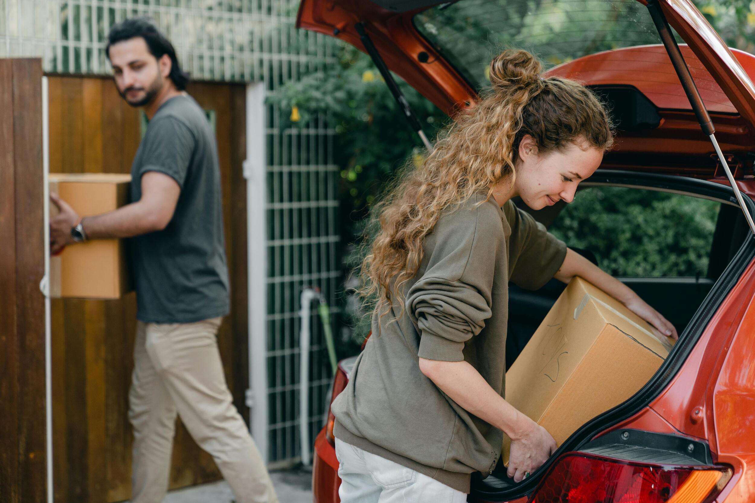 Man and women unpacking the boxes from their car