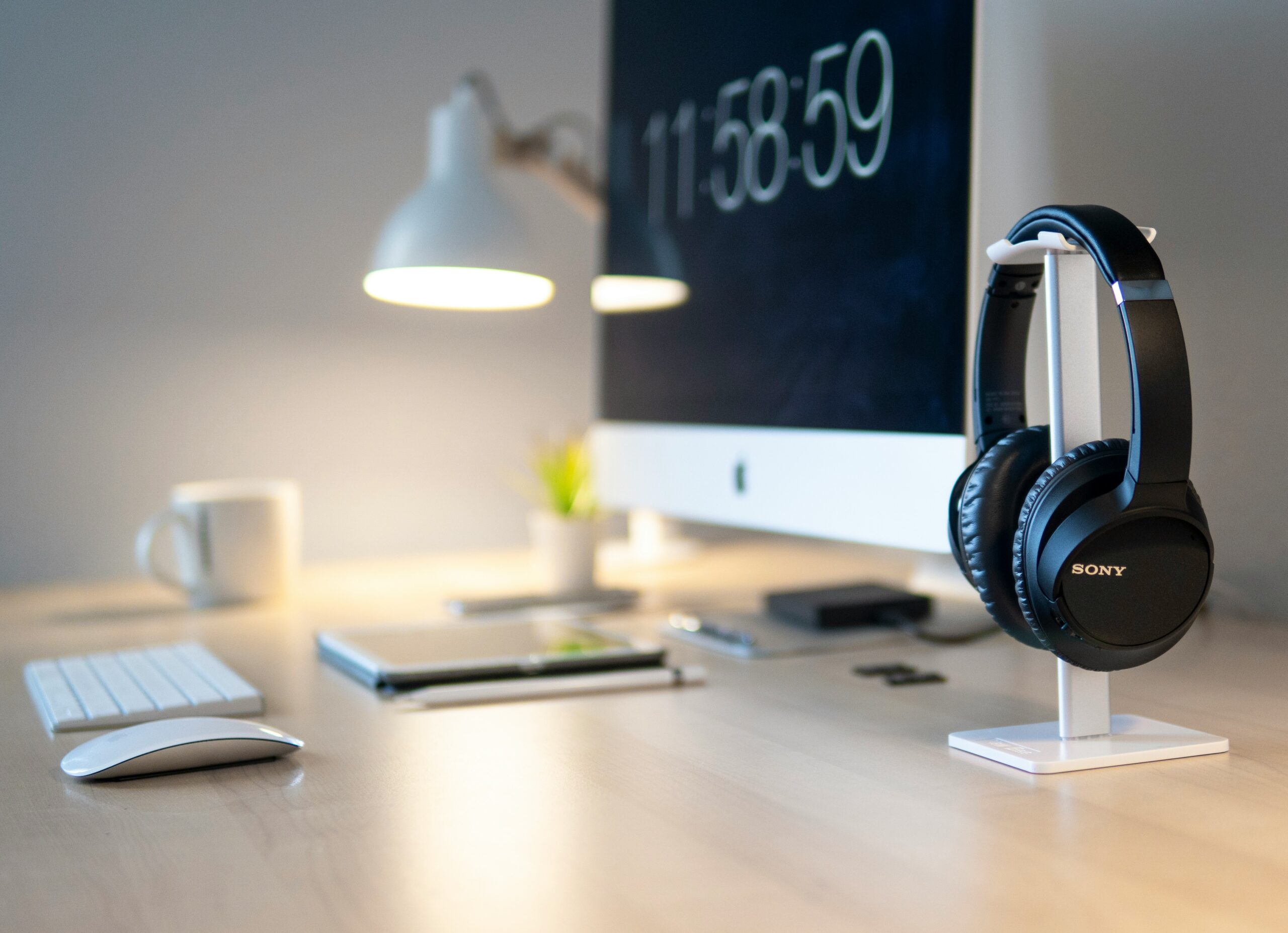 Black Sony headphones beside iMac on top of desk